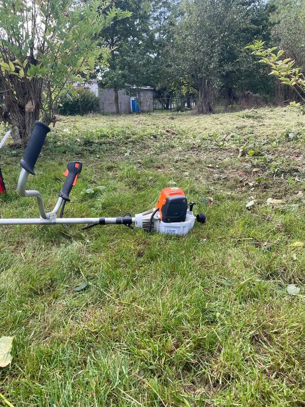 Débroussailleuse posée sur l’herbe coupée d’un terrain dégagé